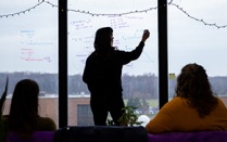 Students with the Glacier Modeling Lab in the Department of Earth Sciences, led by Kristin Poinar, meet in their Hochstetter Hall lab space in December 2023. They are mixing fieldwork with the latest developments in AI to map and understand the ever-changing glacial ice in Greenland. PhD candidate Courtney Shafer takes notes on the windows. Photographer: Meredith Forrest Kulwicki. 