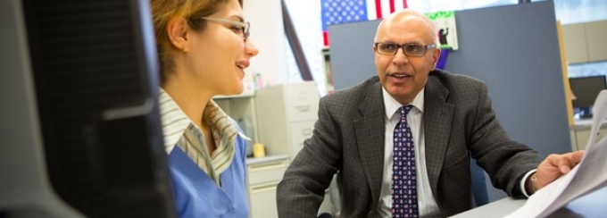 Photo of Rajan Batta speaking with a student. 