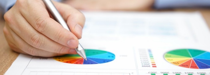 Photo of a hand holding a pen with report. 