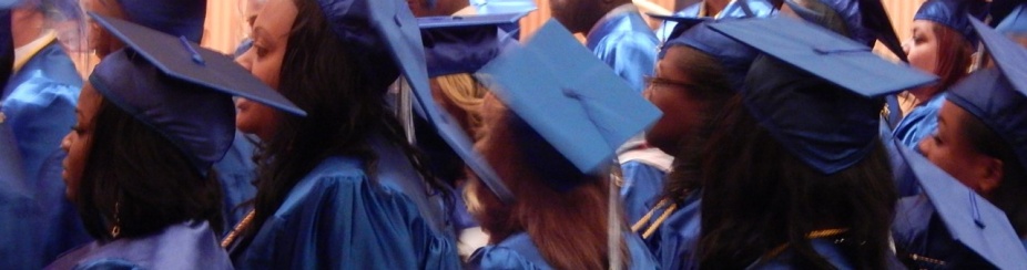 Students stand in cap in gown. 