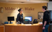 Students talking at the front desk of the Mildred H. Blake academic success center. 