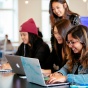 happy, smiling students looking for jobs in Bullseye powered by handshake on a laptop. 