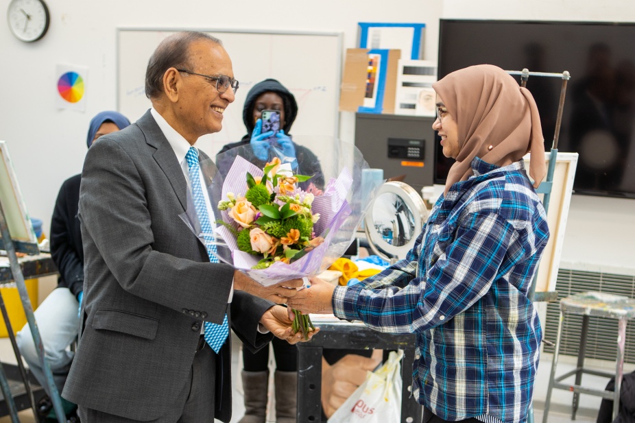 President Satish Tripathi surprised student Samiha Islam (right) in her paint class at the CFA in April 2023. Samiha Islam won the Harry S. Truman Scholarship. Photographer: Douglas Levere. 