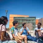 Students talking outside of Davis Hall on a sunny day. 