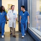 three people walking down a hallway. 