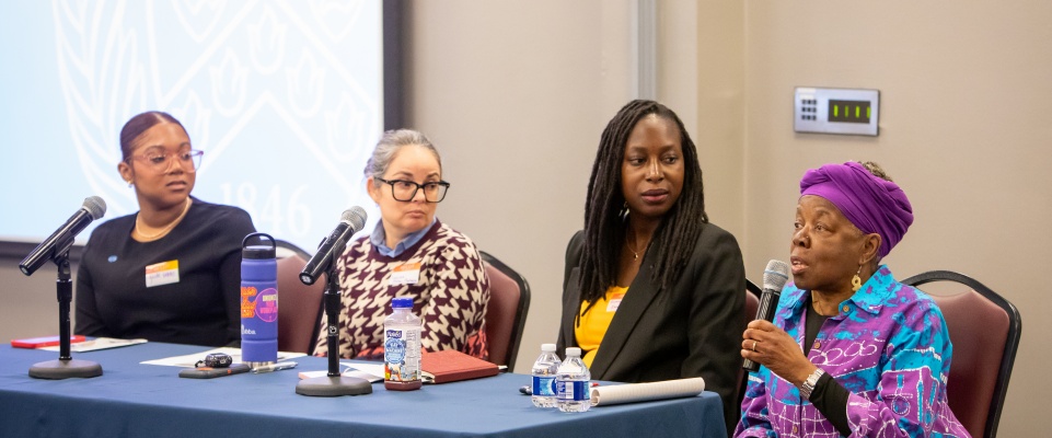 Yaide Valdez, Louisa Fletcher-Pacheco, and Anyango Kamina listening to Karima Amin speak during the plenary panel at the Women's History Month symposium. 