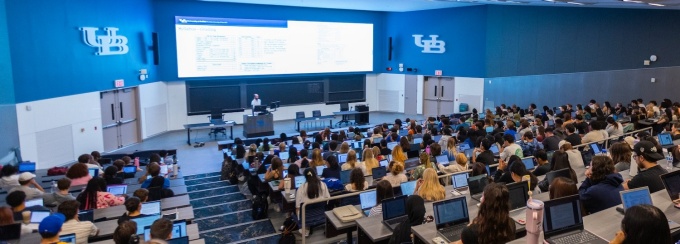 Students in a large lecture hall. 